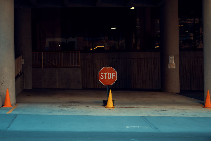 Stop sign and orange cones at garage entrance.